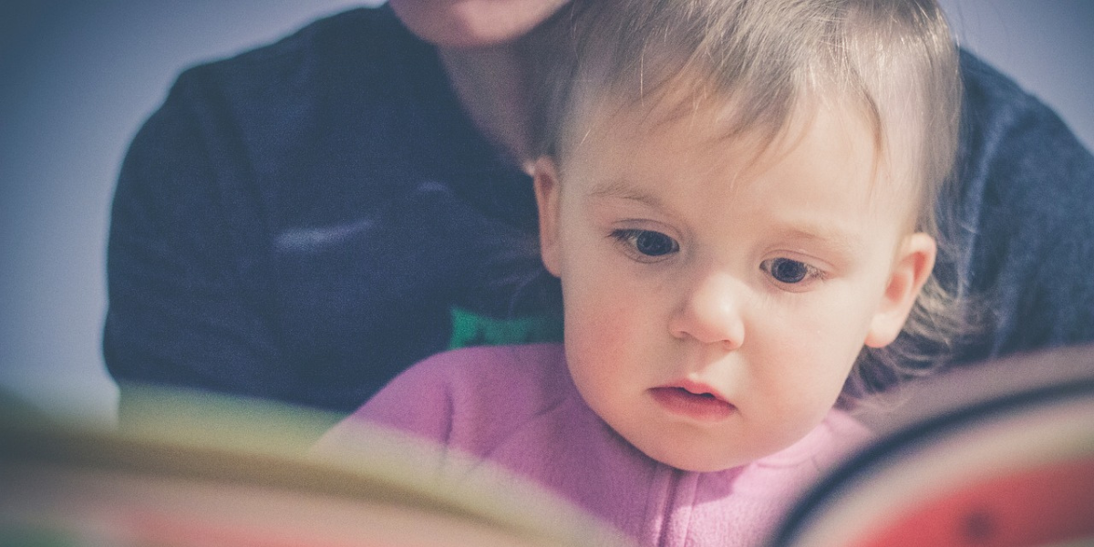 bambino in primo piano che legge un libro